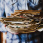 guy-holds-stack-old-newspapers-with-books-close-up-without-face-collection-old-newspapers_78450-1462